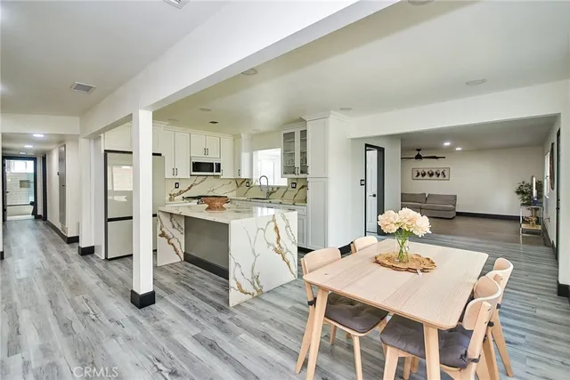 a living room with stainless steel appliances kitchen island granite countertop furniture and wooden floor