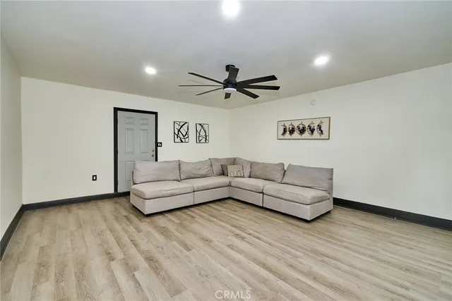 a living room with furniture and a ceiling fan