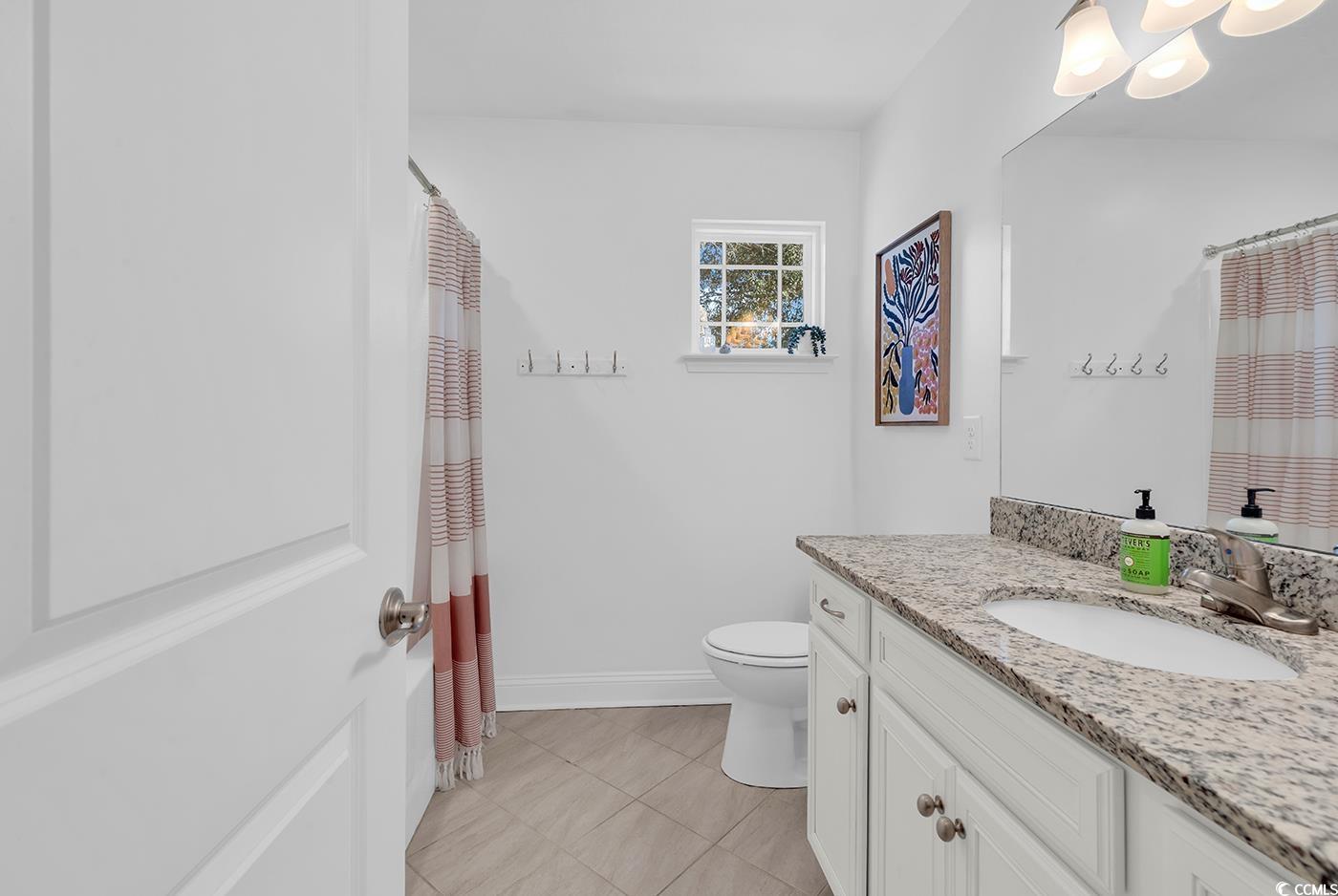 327-a&b Sparrow Drive Surfside Beach, SC 29575 - Photo 15 of 33 Full bath featuring curtained shower, vanity, and light tile patterned floors