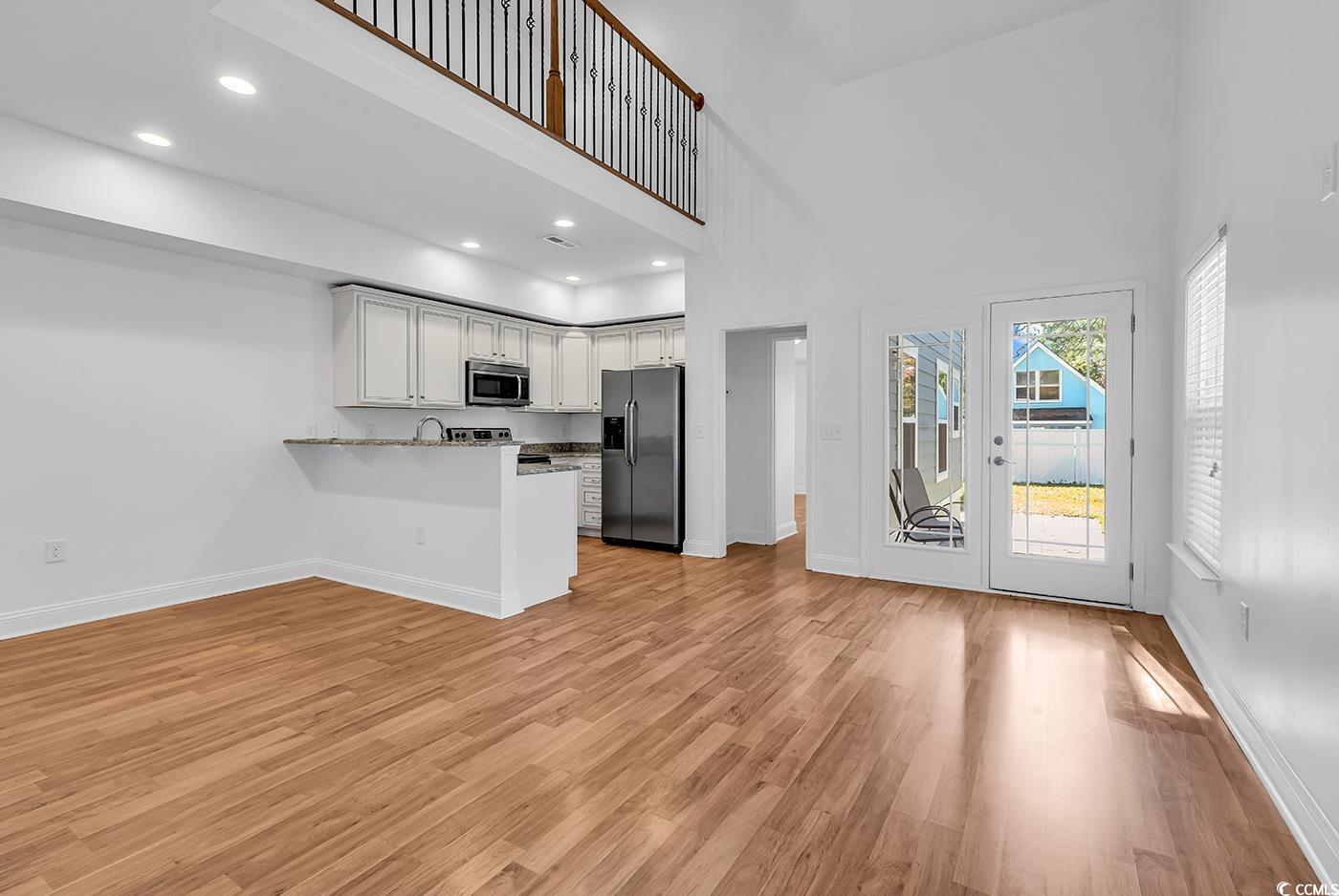 327-a&b Sparrow Drive Surfside Beach, SC 29575 - Photo 20 of 33 Kitchen featuring white cabinetry, a high ceiling, stainless steel appliances, a peninsula, and recessed lighting