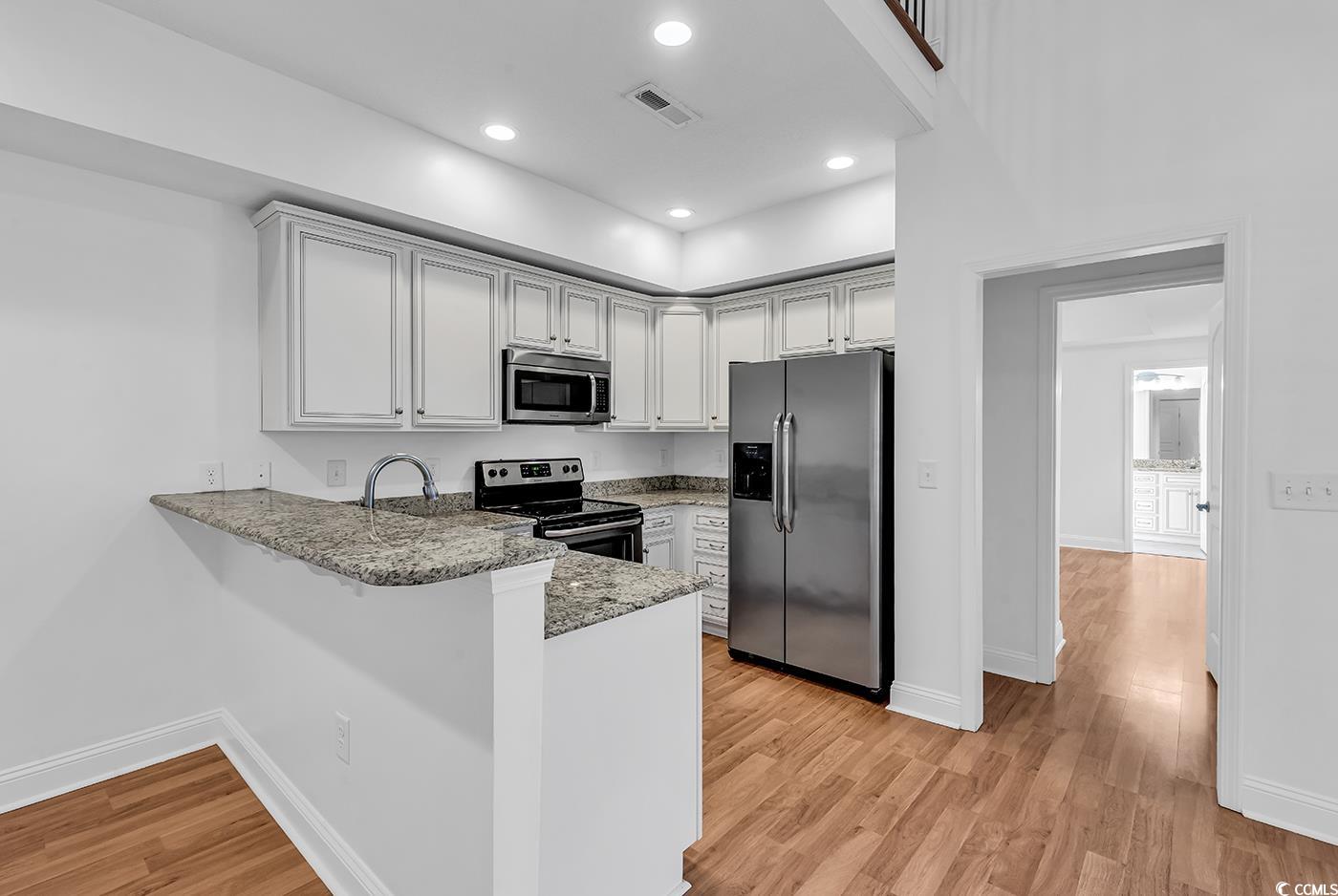 327-a&b Sparrow Drive Surfside Beach, SC 29575 - Photo 22 of 33 Kitchen featuring stainless steel appliances, light stone counters, a peninsula, light wood finished floors, and recessed lighting