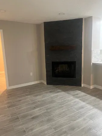a view of empty room with wooden floor and a window