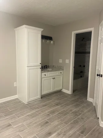 a view of a kitchen with white cabinets and refrigerator
