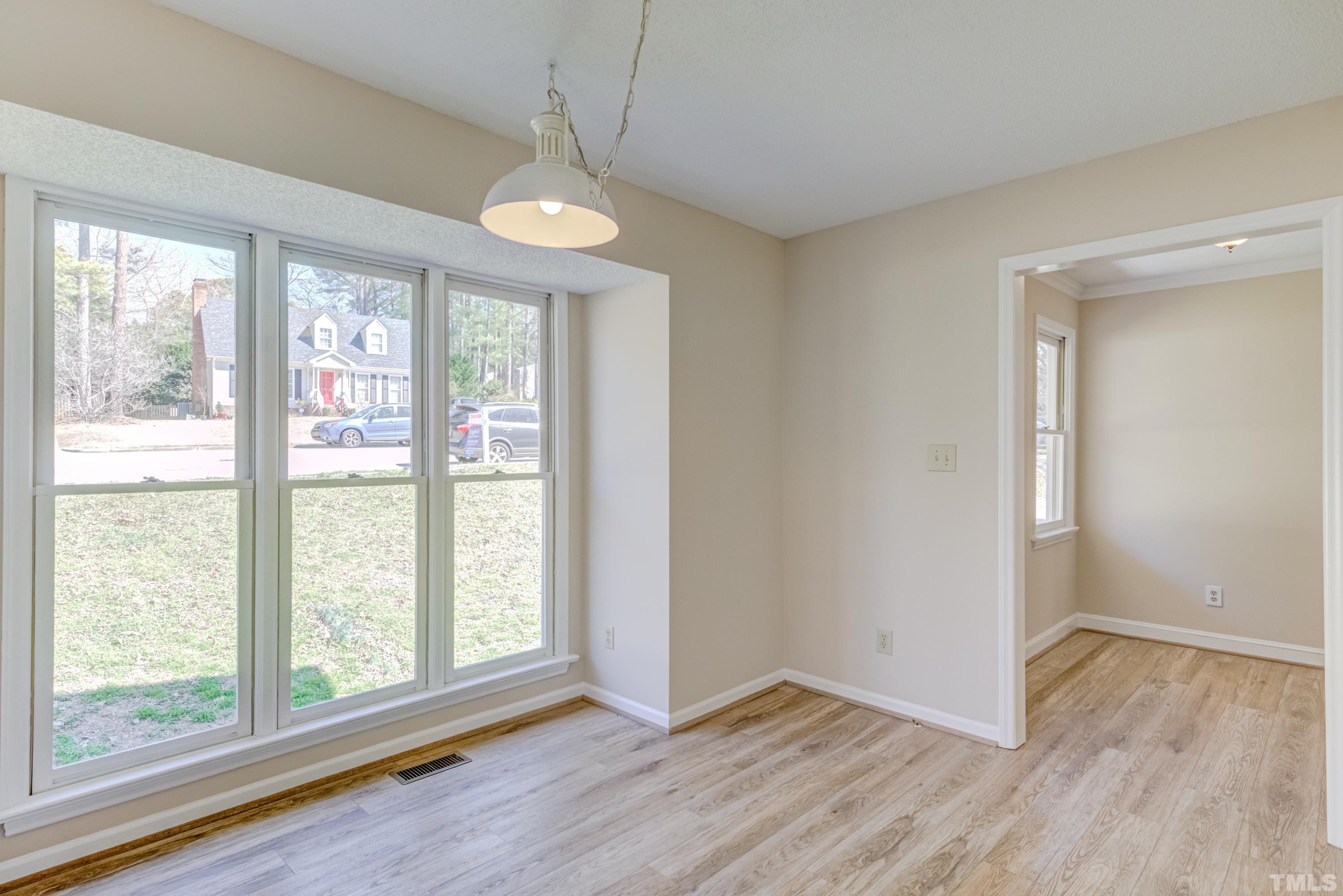 7307 Wilderness Road Raleigh, NC 27613 - Photo 6 of 14 a view of an empty room with wooden floor and a window