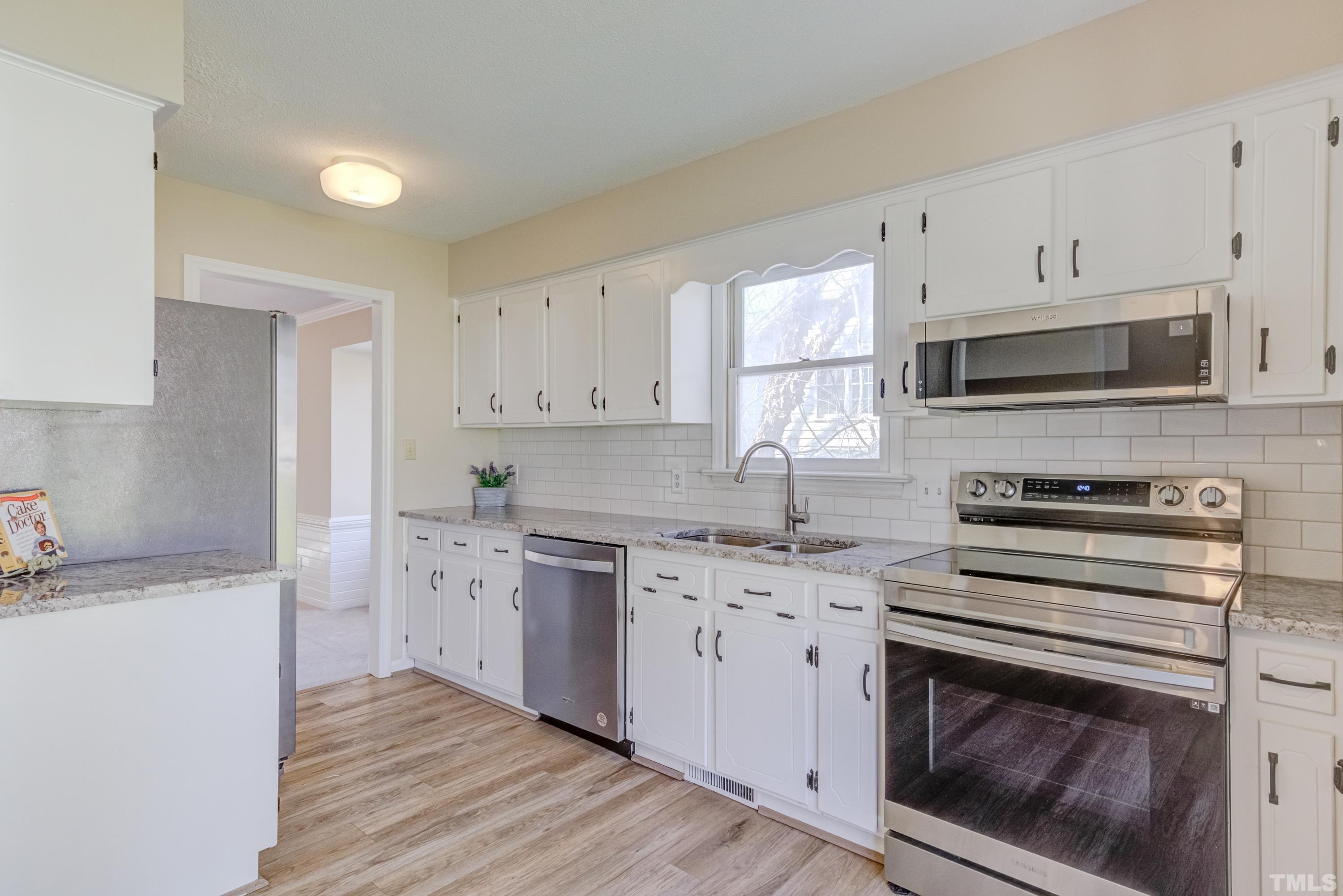 7307 Wilderness Road Raleigh, NC 27613 - Photo 7 of 14 a kitchen with cabinets stainless steel appliances and a sink
