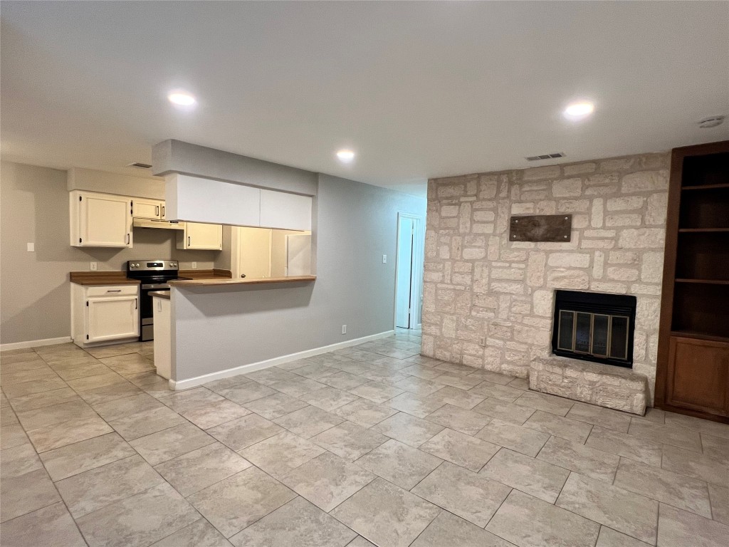 209 East Noton Street, Unit 110 Pflugerville, TX 78660 - Photo 1 of 1 a kitchen with stainless steel appliances granite countertop a stove top oven a sink and a microwave