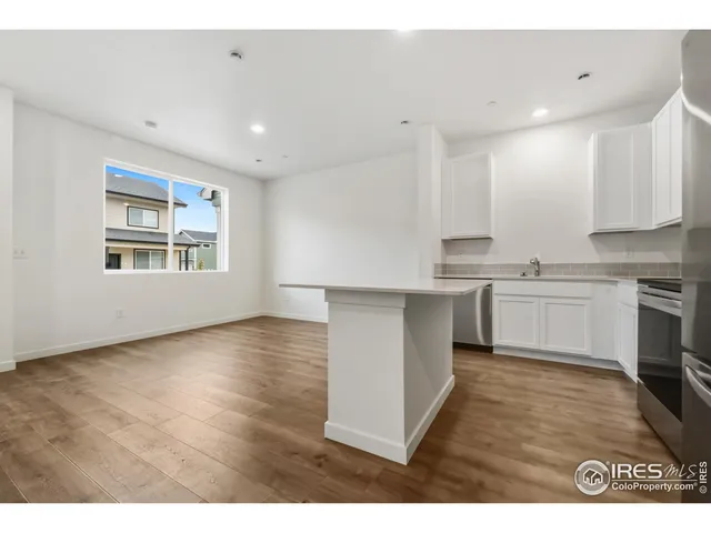 a kitchen with cabinets wooden floor and stainless steel appliances