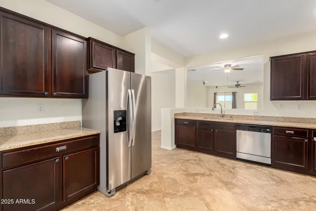 a large kitchen with stainless steel appliances granite countertop a refrigerator and a sink