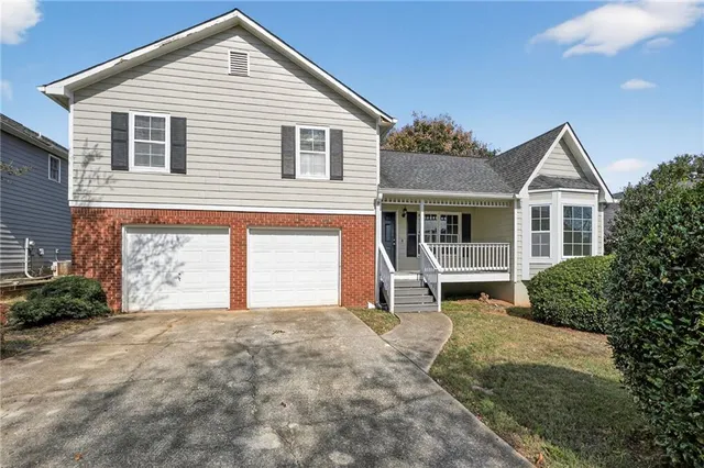 a front view of a house with a garden and trees