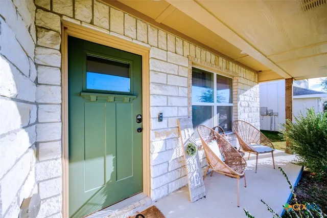 a view of patio with a table and chairs and potted plants