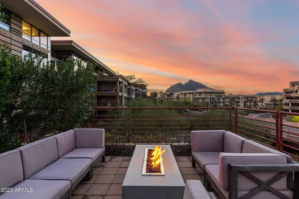 a living room with white couches and white cabinets with wooden floor