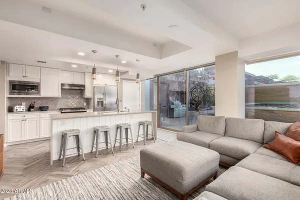a large white kitchen with a large window and stainless steel appliances