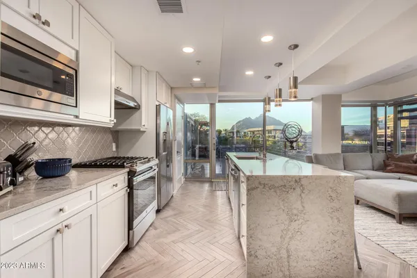 a kitchen with kitchen island a counter top space appliances and cabinets