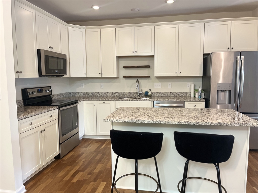 110 Trotter Road, Unit 308 Weymouth, MA 02190 - Photo 1 of 11 a kitchen with stainless steel appliances granite countertop a stove a sink a microwave a refrigerator and white cabinets