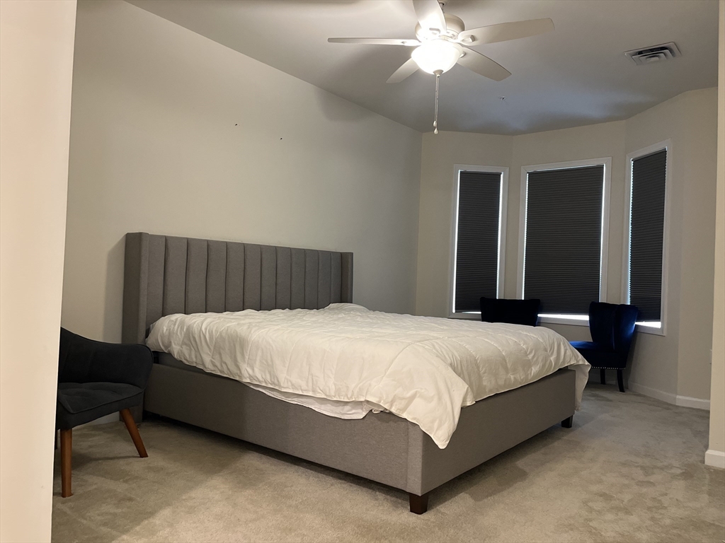 110 Trotter Road, Unit 308 Weymouth, MA 02190 - Photo 7 of 11 a bedroom with a bed lamp and a chandelier