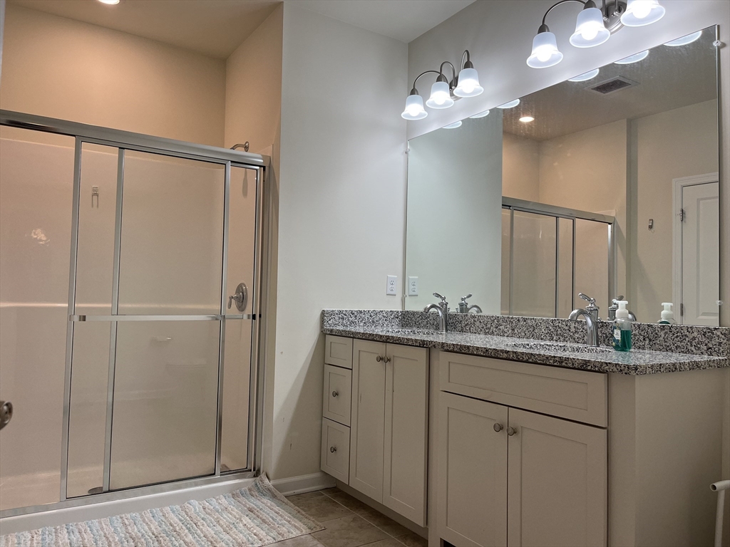 110 Trotter Road, Unit 308 Weymouth, MA 02190 - Photo 8 of 11 a bathroom with a granite countertop sink a mirror and a shower