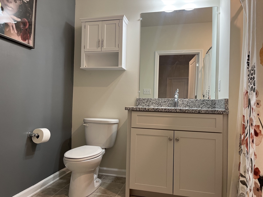 110 Trotter Road, Unit 308 Weymouth, MA 02190 - Photo 10 of 11 a bathroom with a granite countertop toilet sink and mirror