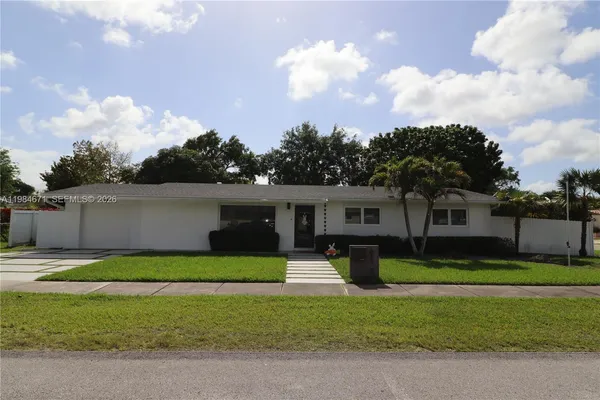 a swimming pool with lawn chairs and wooden fence