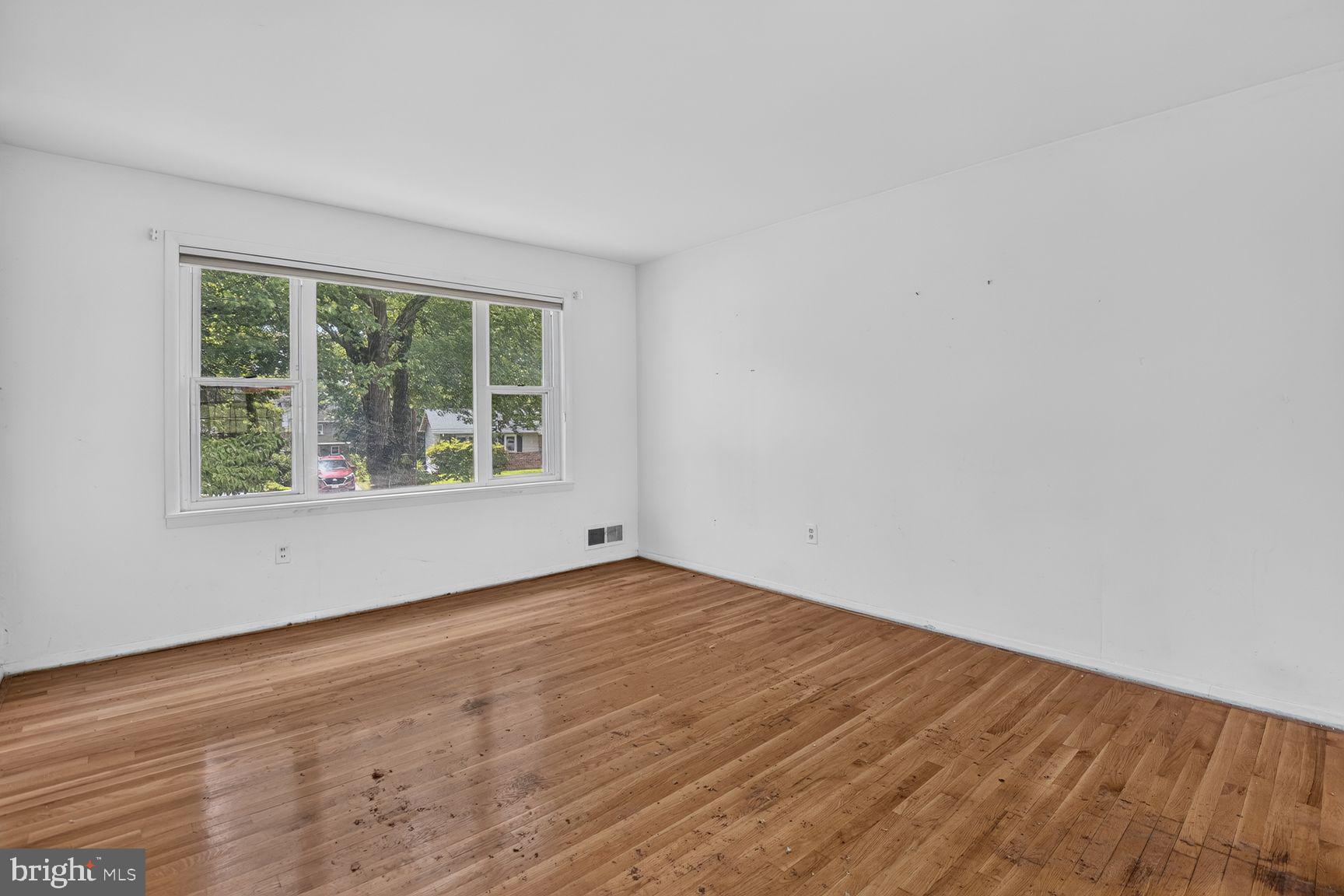 1326 Gresham Road Silver Spring, MD 20904 - Photo 9 of 30 a view of an empty room with wooden floor and a window