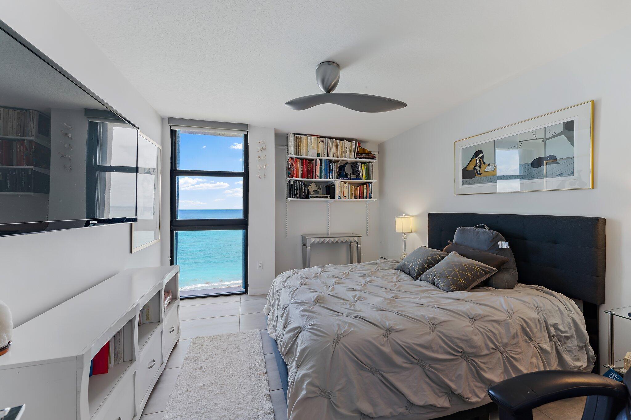 450 Ocean Drive, Unit 905 Juno Beach, FL 33408 - Photo 14 of 37 a bedroom with a large bed and a chandelier