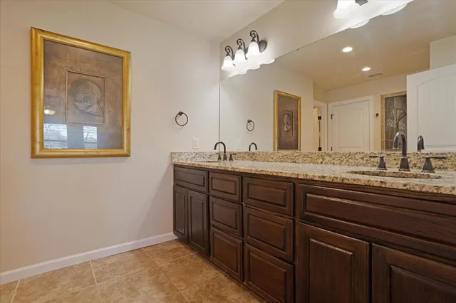 a bathroom with a granite countertop sink a large mirror and a window