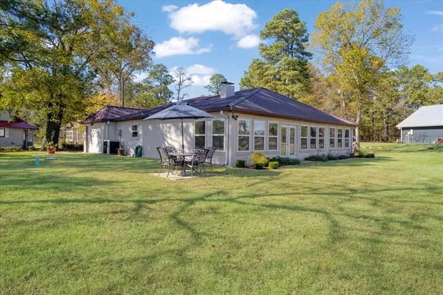 a view of a house with a big yard and large trees
