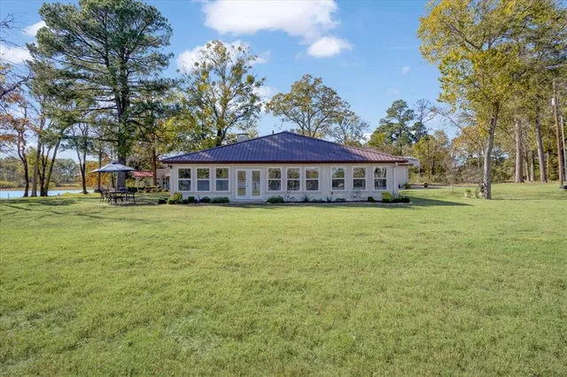 a view of a house with a patio and a yard