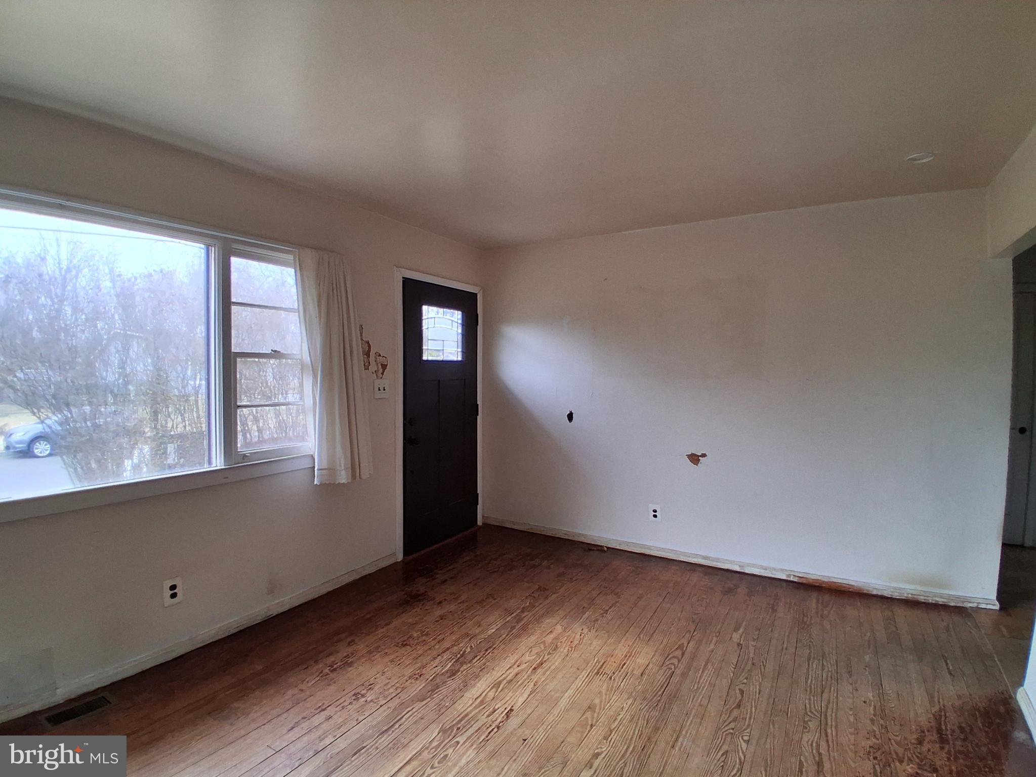 643 North Main Street Clayton, NJ 08312 - Photo 2 of 8 an empty room with wooden floor and windows