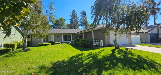 a view of a house with a yard and tree s