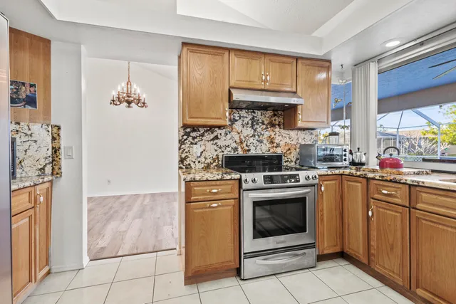 a kitchen with stainless steel appliances granite countertop a stove a refrigerator and a sink