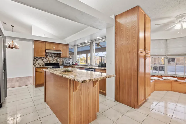 a kitchen with stainless steel appliances granite countertop a stove a sink and a refrigerator