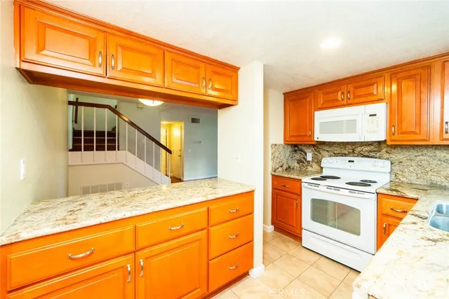 a kitchen with stainless steel appliances granite countertop a stove a sink and a microwave