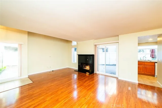 a view of empty room with wooden floor and fireplace