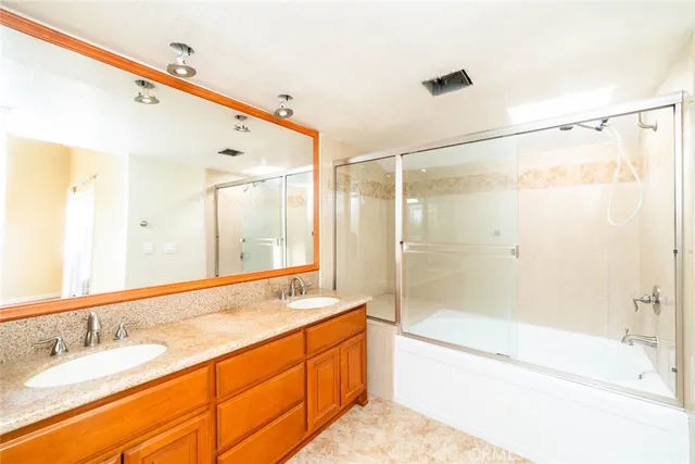 a bathroom with a granite countertop sink mirror shower and a bathtub