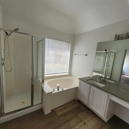 a bathroom with a tub a sink and a mirror