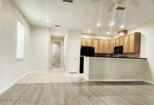 a view of a kitchen with kitchen island wooden floor center island and stainless steel appliances