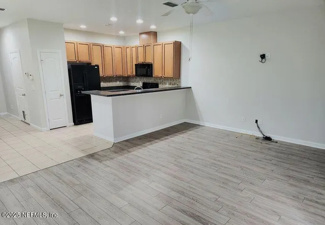 a view of kitchen with refrigerator and window