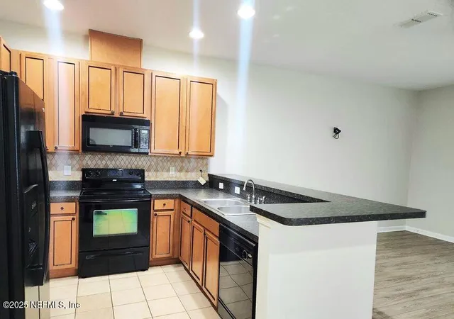 a kitchen with stainless steel appliances granite countertop a stove a sink and a microwave