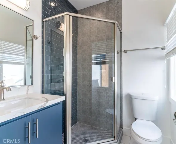 a bathroom with a shower sink vanity mirror and toilet