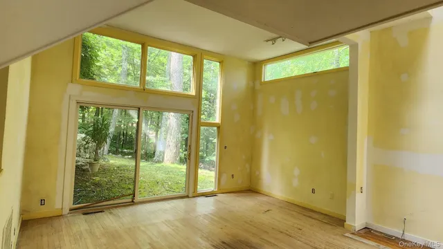 a view of an empty room with wooden floor and doors