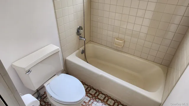 a white toilet sitting next to a bath tub