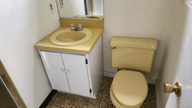 a bathroom with a sink a toilet and a mirror