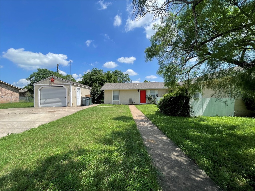 Ranch-style house featuring driveway, an outdoor structure, and a garage