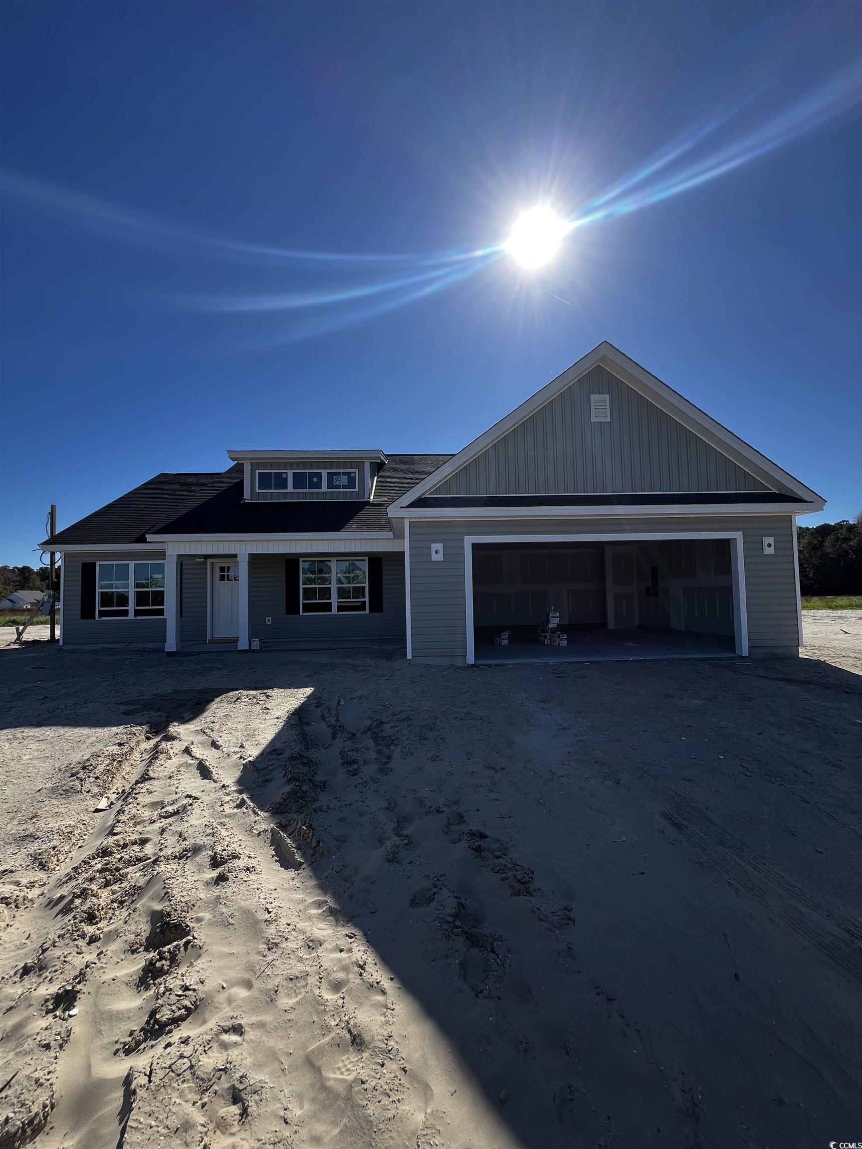 View of front of house featuring driveway, covered porch, and an attached garage