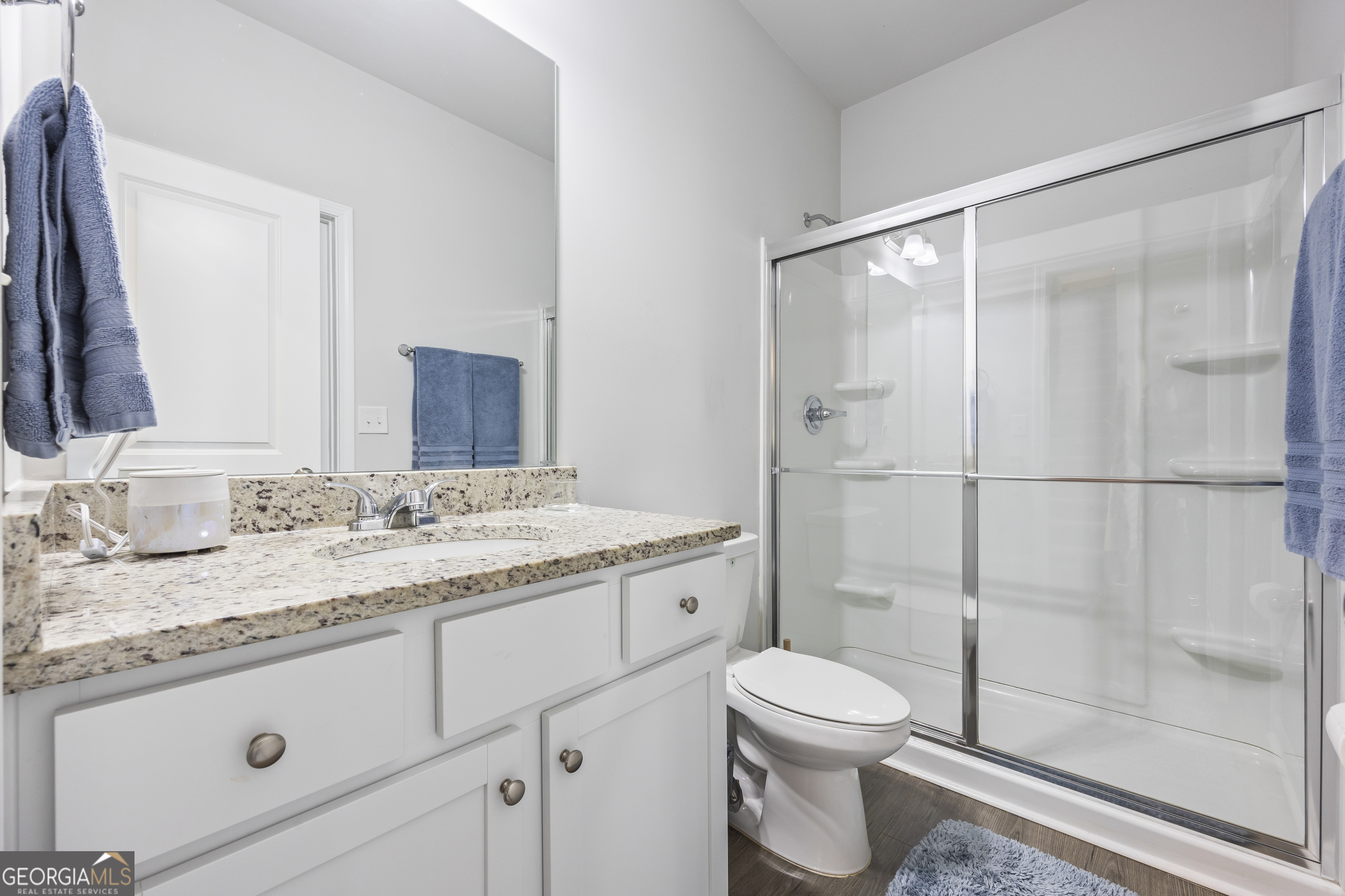 1064 Emmas Path Monroe, GA 30656 - Photo 13 of 55 a bathroom with a granite countertop sink toilet mirror and shower