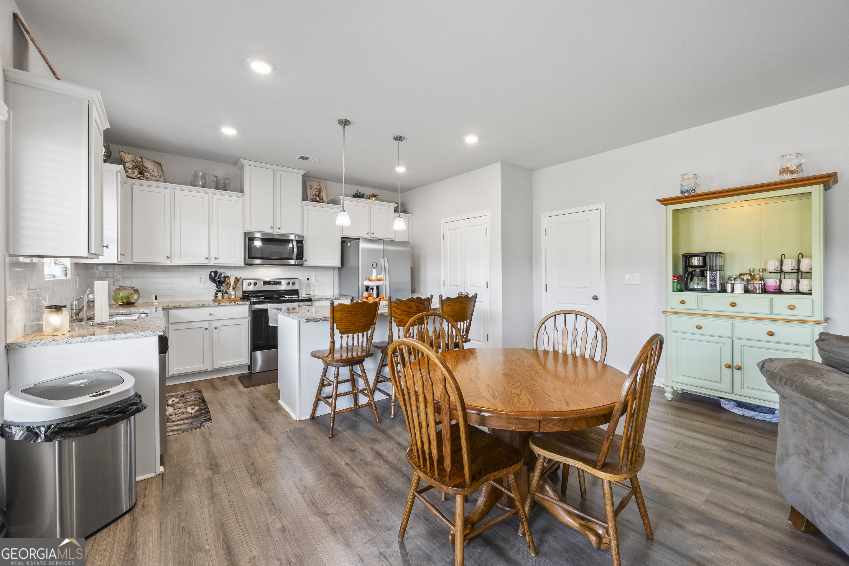 1064 Emmas Path Monroe, GA 30656 - Photo 17 of 55 a kitchen with stainless steel appliances a dining table chairs stove refrigerator and cabinets