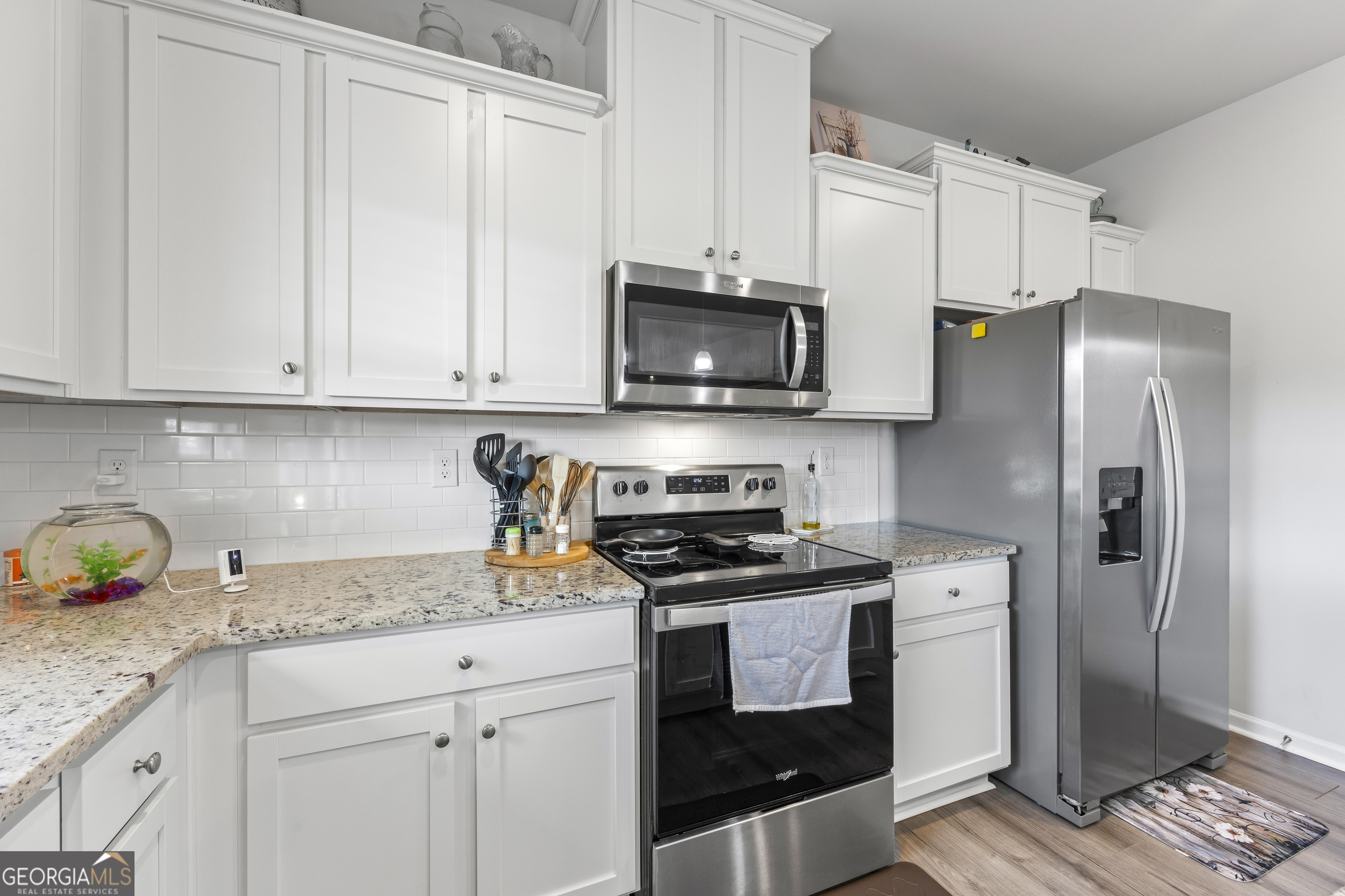 1064 Emmas Path Monroe, GA 30656 - Photo 21 of 55 a kitchen with granite countertop a refrigerator stove and microwave
