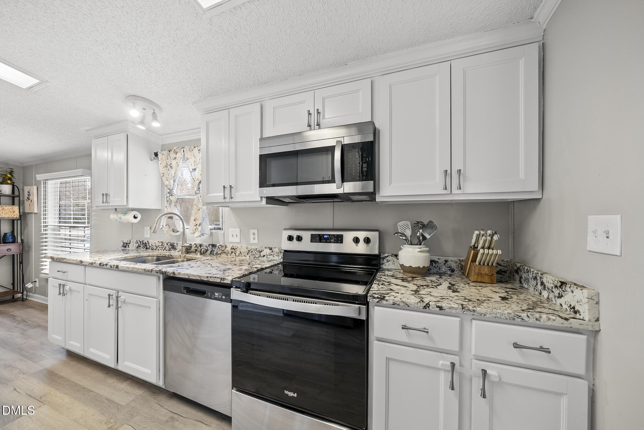 4703 Trinity Lane Rougemont, NC 27572 - Photo 20 of 55 a kitchen with granite countertop white cabinets and stainless steel appliances