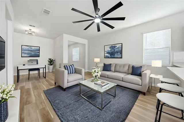 a living room with furniture a ceiling fan and a rug