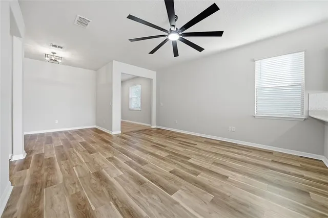 a view of empty room with wooden floor